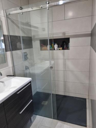 a shower with a glass door in a bathroom at La maison lumineuse in Hénin-Beaumont