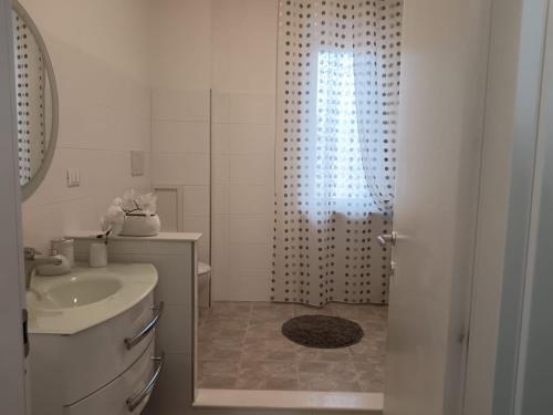 y baño blanco con lavabo y ducha. en Parco delle Rose, en Sulmona