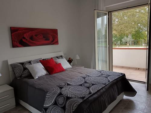 1 dormitorio con 1 cama grande con almohadas rojas en Parco delle Rose, en Sulmona