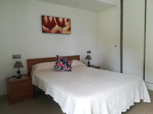 een slaapkamer met een wit bed met een kussen erop bij Mirador de La Cala JPC in Benidorm