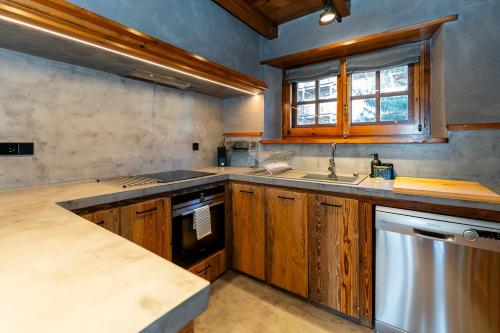 a kitchen with wooden cabinets and a sink and a dishwasher at Pleta del Tarter Lodge in El Tarter
