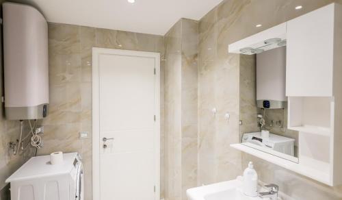 ein Badezimmer mit einem weißen Waschbecken und einem Spiegel in der Unterkunft Premium Apartment in the Center in Tirana