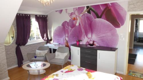 a bedroom with a large purple flower on the wall at Blumen Apartment in Hamburg