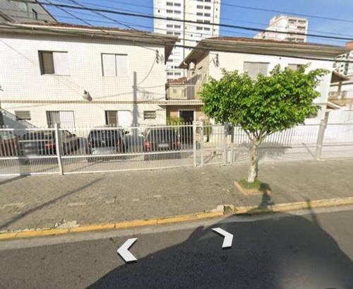 une rue vide avec un arbre et une clôture dans l'établissement kit próximo da praia, à Praia Grande