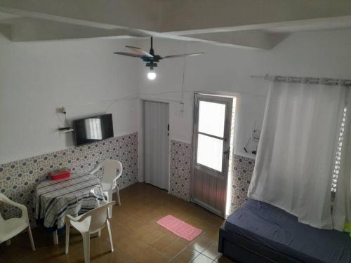 - une chambre avec un lit, une table et une fenêtre dans l'établissement kit próximo da praia, à Praia Grande