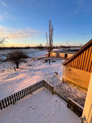 a snow covered porch of a house with a fence at Havlykkegaard - en unik gammel dame ved Østersøen in Idestrup