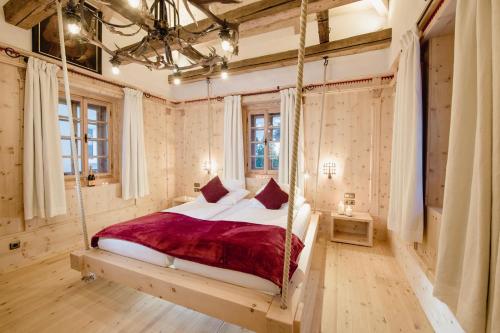 a bedroom with a hanging bed in a room at Hotel Norica - Thermenhotels Gastein mit dem Bademantel direkt in die Therme in Bad Hofgastein
