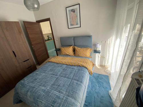 um quarto com uma cama com um edredão azul em Callisto skg em Tessalônica