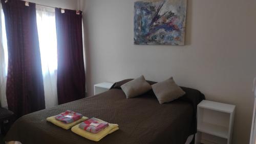 Un dormitorio con una cama con dos toallas encima. en Belmar Santa Teresita, en Santa Teresita