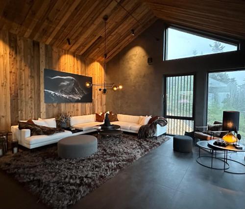 uma sala de estar com sofás brancos e um tapete grande em Norefjell Chalet em Surteberg