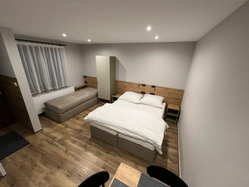 um quarto com uma cama e um sofá em Noclegi u Alicji- Apartamenty em Gołuchów
