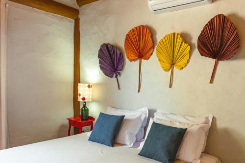 a bedroom with colorful paper umbrellas on the wall at Casa Caroá - Chalé 3 in Japaratinga