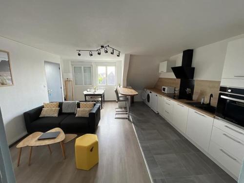 een woonkamer met een bank en een keuken bij Logement au centre du Conquet in Le Conquet