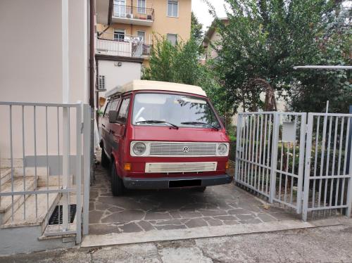 a red van is parked next to a fence at Casa Zoe in Piacenza