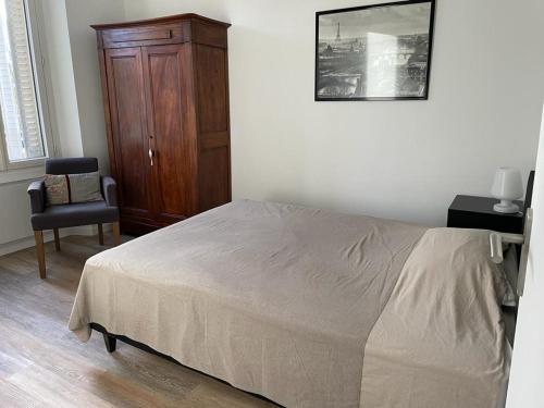 une chambre avec un lit, une commode et une chaise dans l'établissement Superbe 2 pièces proche Nation, à Paris