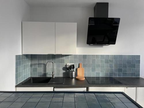 une cuisine avec un évier et un plan de travail dans l'établissement Superbe 2 pièces proche Nation, à Paris