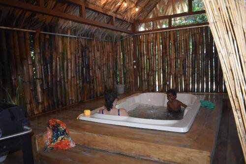 dos personas en una bañera en una cabaña en Casita Flor de Loto, en Puerto Viejo