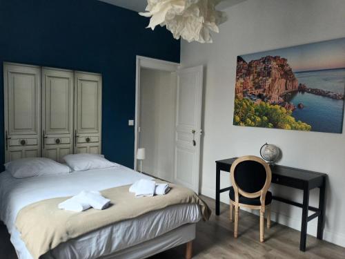 een slaapkamer met een bed, een bureau en een stoel bij Suite PREMIUM LE FIGARO 1 in Épernay