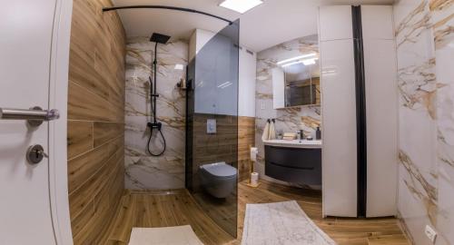 a bathroom with a shower and a toilet and a sink at Apartman Bono in Sinj