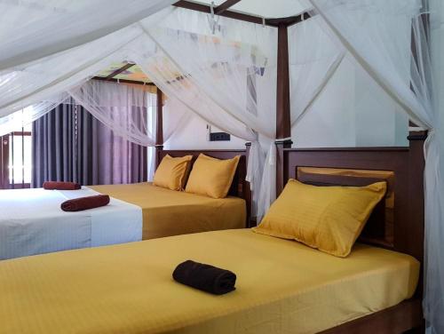 a bedroom with two beds and a tent at Happy house mirissa in Kamburugamuwa