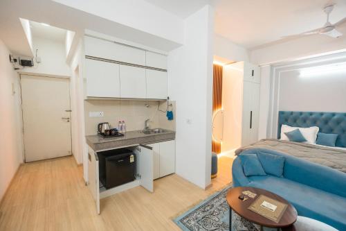 a living room with a blue couch and a bed at Skystay Apartments in Lucknow