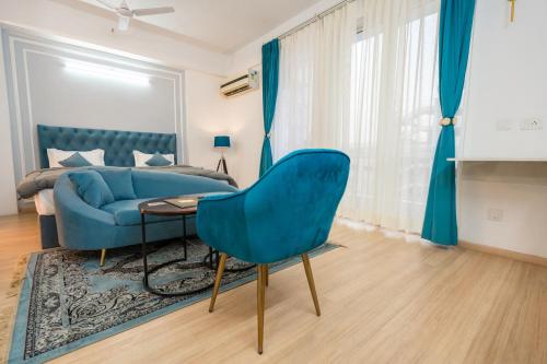 a living room with a blue chair and a couch at Skystay Lucknow in Lucknow