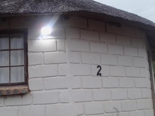 a small white brick building with a black number on it at Slubani in Eshowe