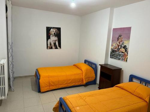 a bedroom with two beds and a dog on the wall at La casa al mare in Policoro