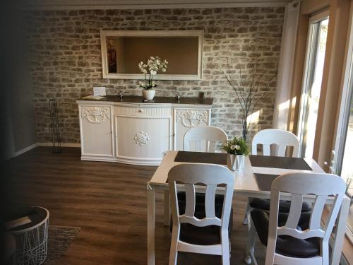 a dining room with a table and white chairs at Ferienwohnung drei Eichen in Isernhagen