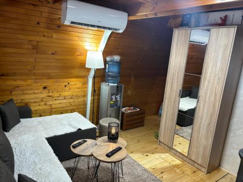 ein Wohnzimmer mit einem Sofa und einem Spiegel in der Unterkunft VILA MAGDA in Divčibare