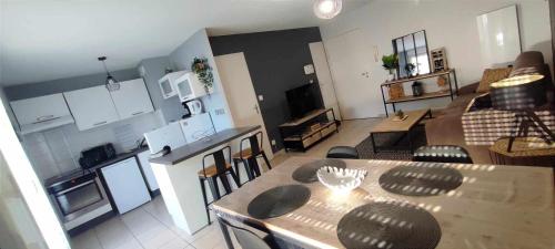 a kitchen and a living room with a dining table at Superbe appartement en résidence avec piscine. in Albertville