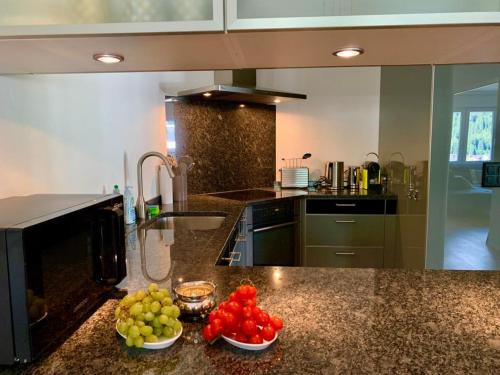 una cocina con tazones de fruta en una barra en WEF DAVOS PLATZ Centre 3,5 Apartment with Garage, en Davos