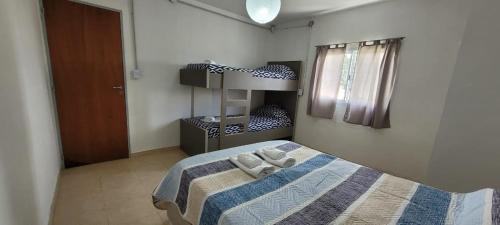 Un dormitorio con una cama con dos toallas encima. en Rio Grande, en Neuquén