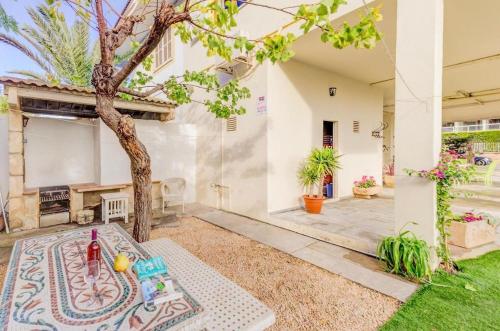 un patio trasero con una mesa y un árbol en Vivienda con piscina a 300 metros de la playa, en Muro