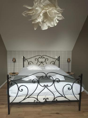 une chambre avec un lit avec un lustre au-dessus dans l'établissement Suite PREMIUM LE FIGARO 2, à Épernay