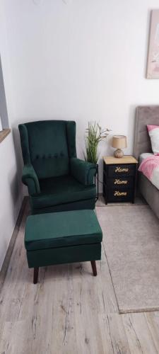 a green chair and a ottoman in a bedroom at STUDIO APARTMAN PAVIĆ in Vinkovci