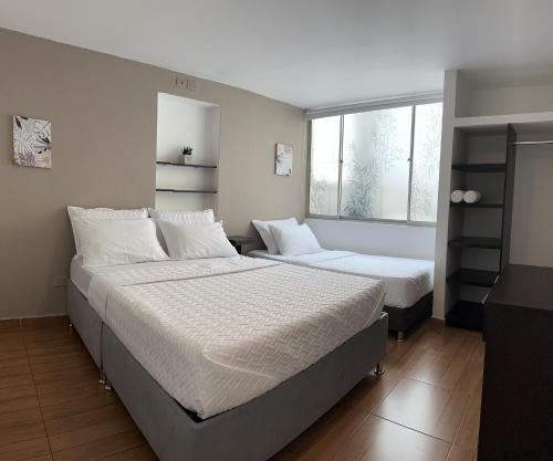 a bedroom with two beds and a window at HOSTELFC CORFERIAS in Bogotá