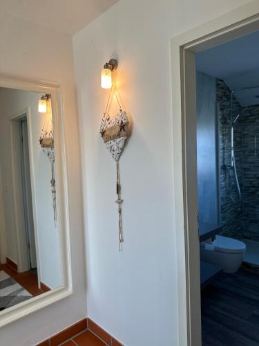 a bathroom with a mirror and a light on the wall at Kapitänskajüte am Bakenberg in Dranske