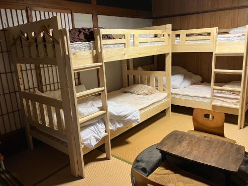 a room with two bunk beds and a table at wagaranchi in Kumano