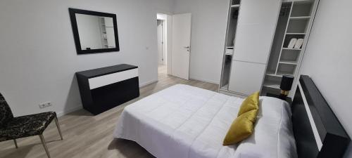 a bedroom with a bed and a mirror and a chair at Azores Blue Bay in Madalena