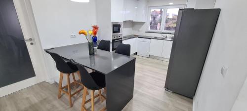 a kitchen with a black counter and some chairs at Azores Blue Bay in Madalena