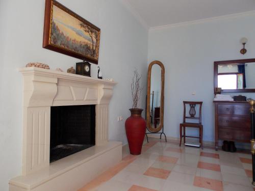 a living room with a fireplace and a vase at Villa Maro in Ágios Stéfanos