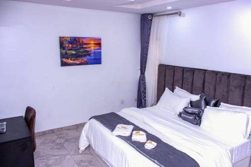 ein Hotelzimmer mit einem Bett mit einem Koffer drauf in der Unterkunft HASB APARTMENTS in Lagos