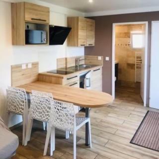 une cuisine avec une table et des chaises en bois dans l'établissement Le petit nid de chessy, à Chessy