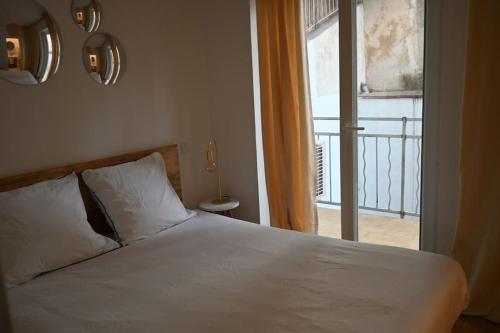 - une chambre avec un lit blanc et un balcon dans l'établissement Chez Zize T2 unique- Roucas-Blanc, à Marseille