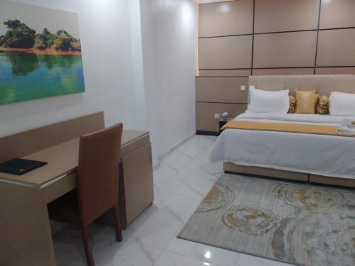 a hotel room with a bed and a desk and a desk at HASB APARTMENTS in Lagos