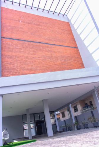 a large building with a red brick wall at HASB APARTMENTS in Lagos