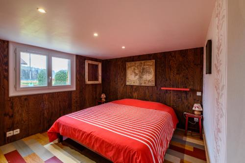 a bedroom with a red bed with a window at Superbes appartements in Mimizan