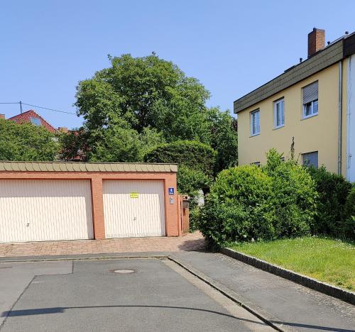 a street with two garages in front of a house at Ferienwohnung Biene in Saarbrücken