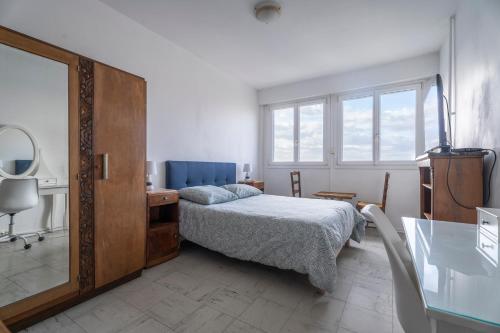 une chambre avec un lit, une commode et un miroir dans l'établissement Vue panoramique, grand appartement 2 chambres à Toulon, à Toulon